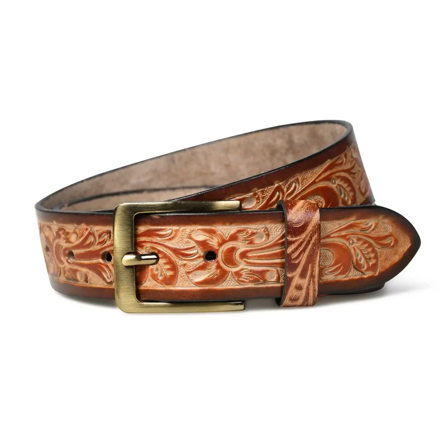 Close-up view of a brown handmade leather belt with a floral design showing detailed texture and stitching.