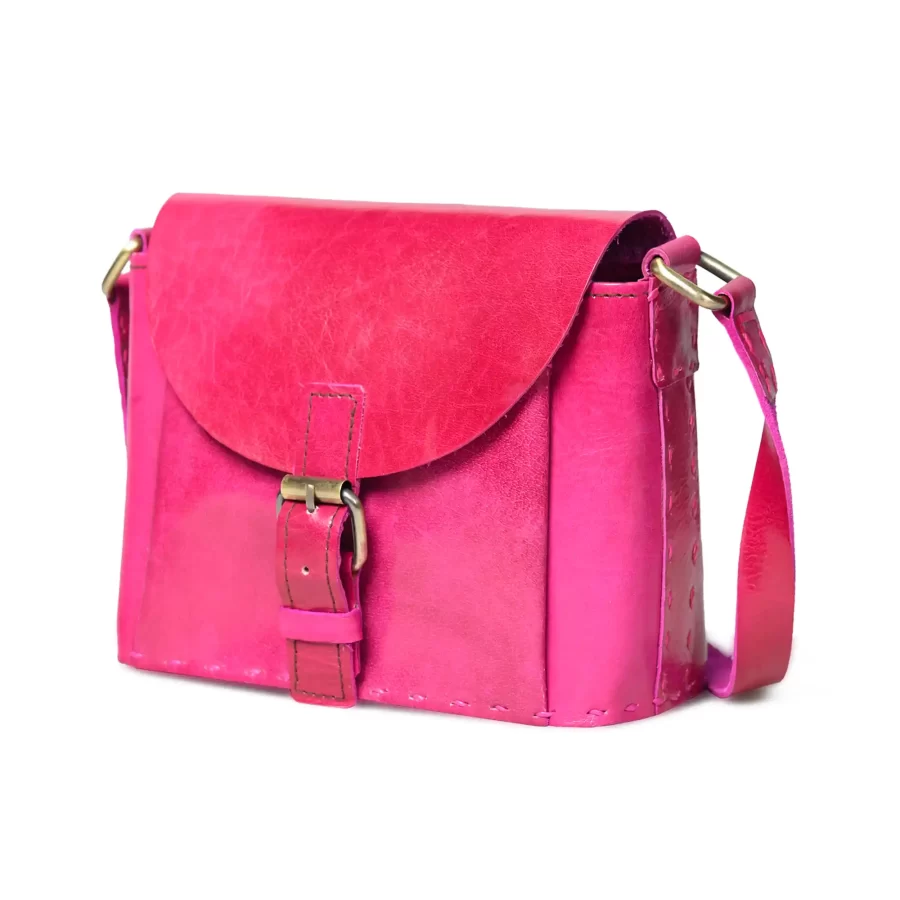 Side view of a pink leather sling bag with buckle 2