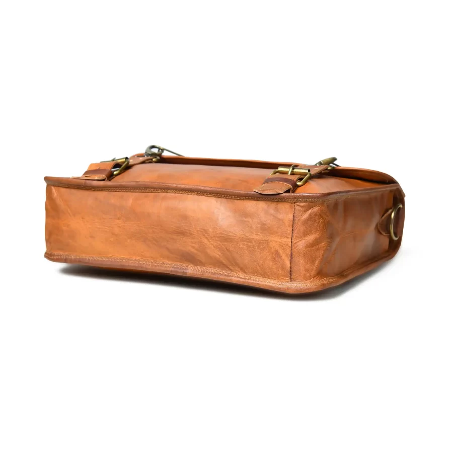 Bottom side view of a tan brown leather messenger with satchel